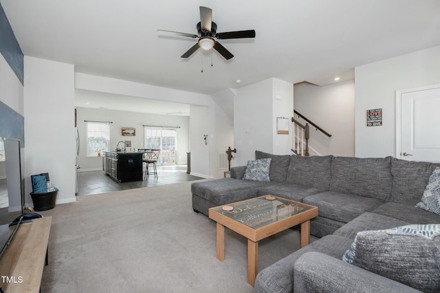 carpeted living room featuring ceiling fan