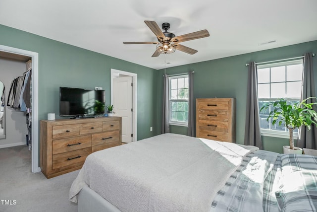 bedroom featuring ceiling fan, multiple windows, a closet, and light carpet