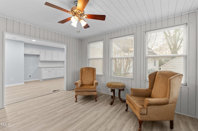 living area with plenty of natural light, light hardwood / wood-style floors, and ceiling fan