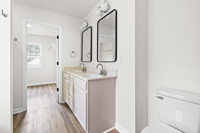 bathroom with toilet, vanity, and hardwood / wood-style flooring