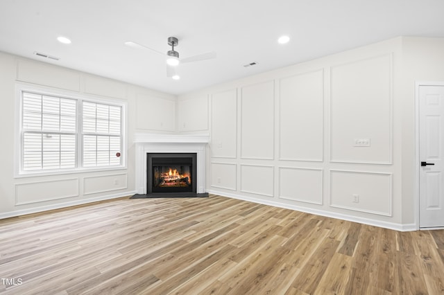 unfurnished living room featuring ceiling fan and light hardwood / wood-style flooring