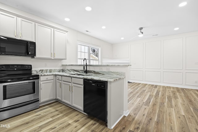 kitchen with light hardwood / wood-style flooring, ceiling fan, black appliances, white cabinets, and sink