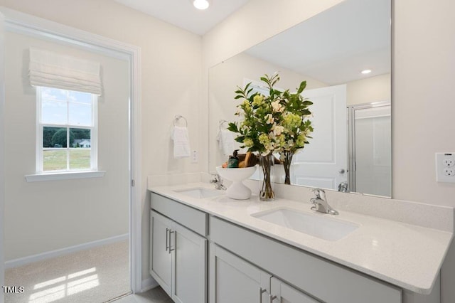 bathroom featuring a shower with door and vanity