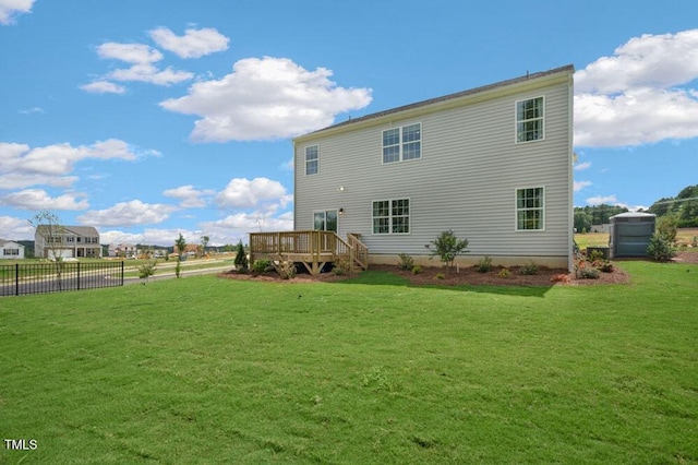 back of house with a wooden deck and a lawn