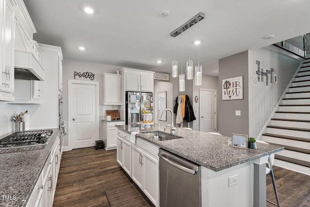 kitchen featuring a kitchen island with sink, appliances with stainless steel finishes, dark hardwood / wood-style floors, sink, and white cabinetry