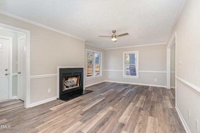 unfurnished living room featuring ceiling fan, crown molding, a textured ceiling, and hardwood / wood-style flooring