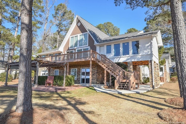 rear view of house with a pergola, a deck, and a lawn