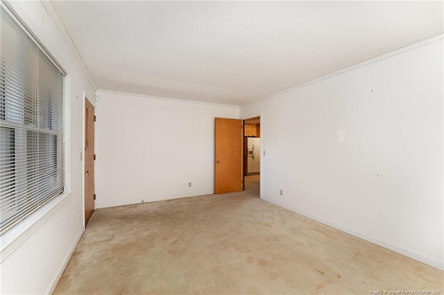 empty room with crown molding and light carpet