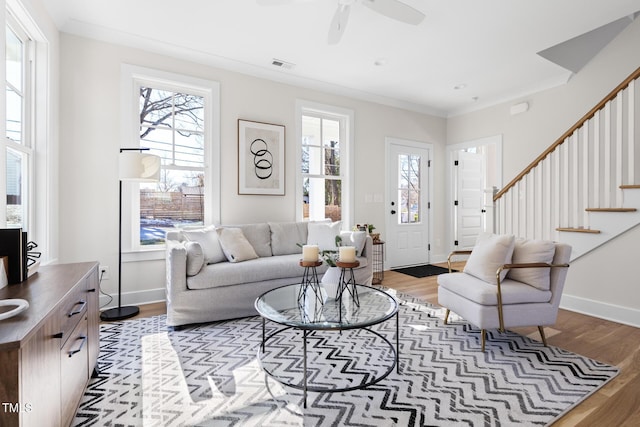 living room with ornamental molding, ceiling fan, and light hardwood / wood-style floors