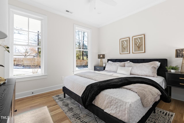 bedroom featuring ornamental molding, light wood-type flooring, and ceiling fan