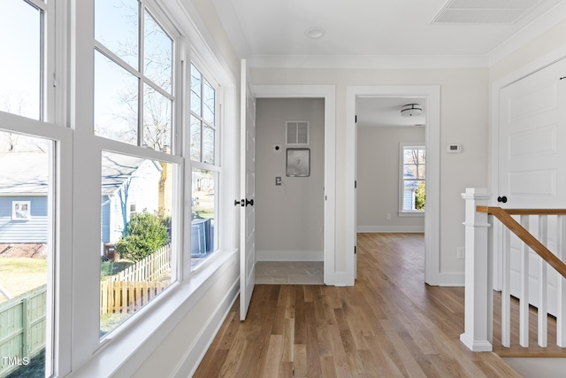 corridor featuring light hardwood / wood-style flooring and crown molding