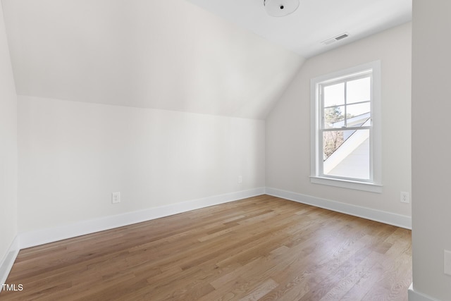 additional living space featuring light hardwood / wood-style flooring and lofted ceiling