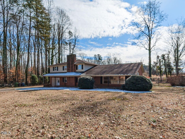 rear view of property featuring a chimney