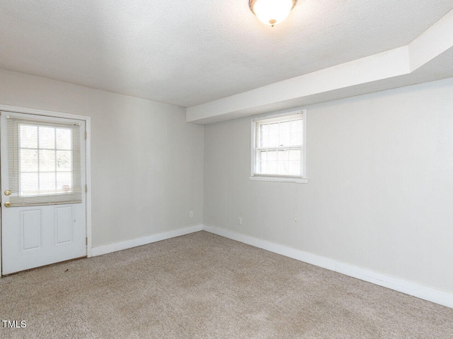 carpeted spare room with a textured ceiling