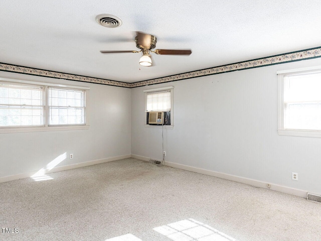 unfurnished room featuring ceiling fan, a healthy amount of sunlight, and cooling unit