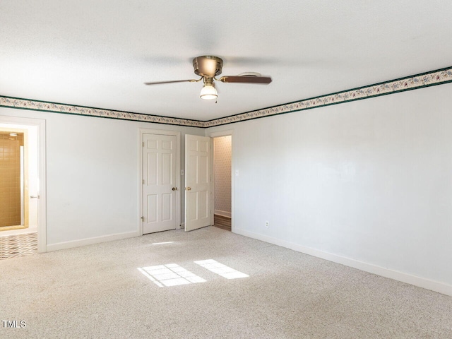 carpeted spare room featuring ceiling fan