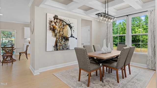 dining area with coffered ceiling, a chandelier, light hardwood / wood-style floors, beamed ceiling, and ornamental molding