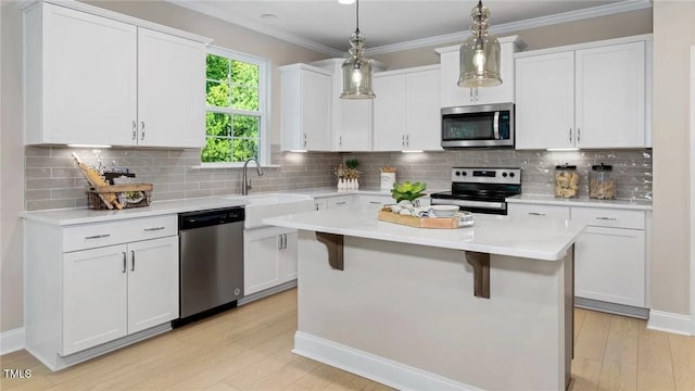 kitchen featuring decorative light fixtures, stainless steel appliances, white cabinets, and tasteful backsplash