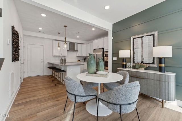 dining space with light hardwood / wood-style floors and sink