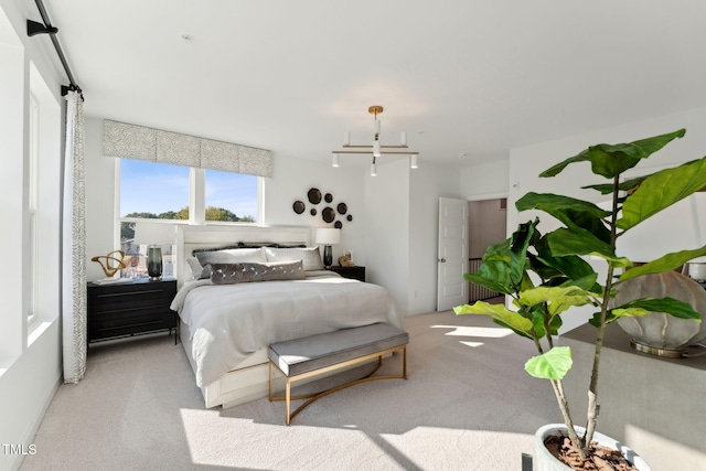 bedroom with an inviting chandelier and light carpet