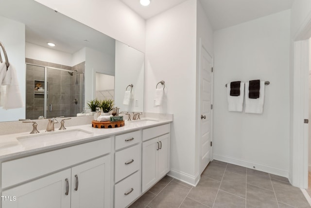 bathroom with tile patterned flooring, a shower with door, and vanity