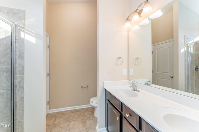 bathroom with tile patterned floors, vanity, toilet, and a shower with door