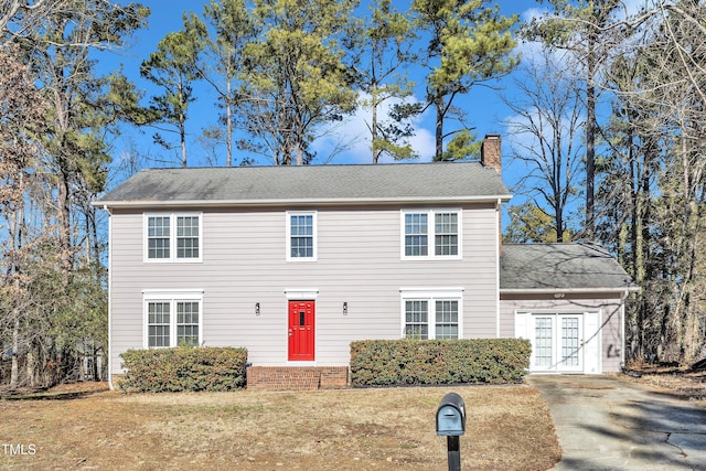 colonial inspired home featuring a front yard and french doors