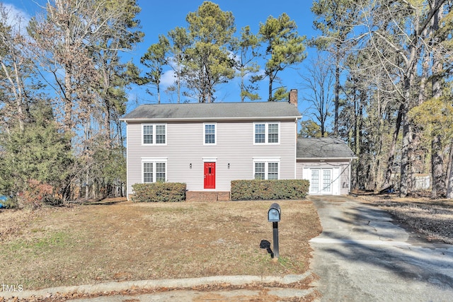 view of front of home with a front yard and french doors