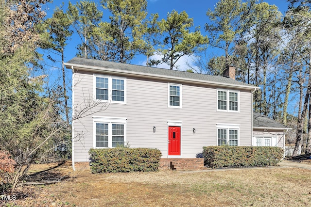 colonial inspired home featuring a front lawn