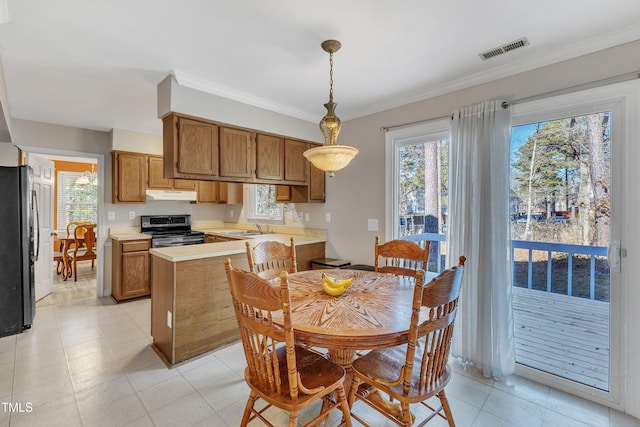 kitchen with pendant lighting, sink, black fridge, stainless steel electric range oven, and crown molding