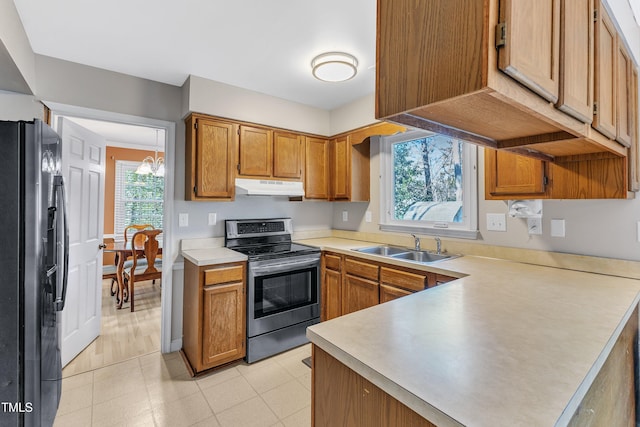 kitchen featuring refrigerator with ice dispenser, a chandelier, stainless steel electric stove, and sink