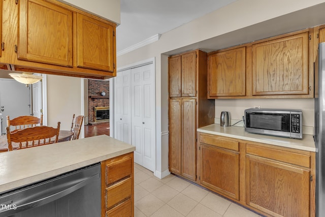 kitchen with appliances with stainless steel finishes, crown molding, and a fireplace