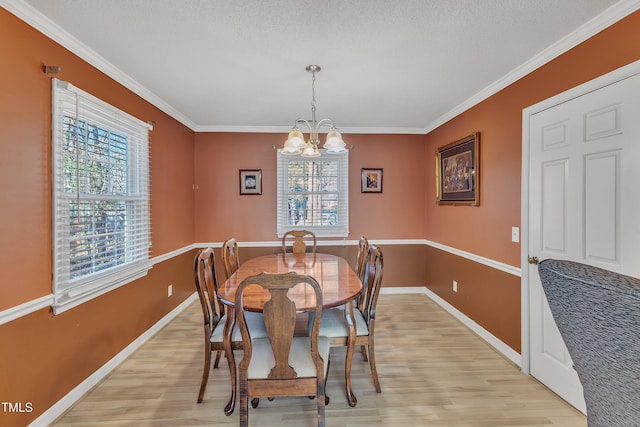 dining room featuring light wood-type flooring, an inviting chandelier, and ornamental molding