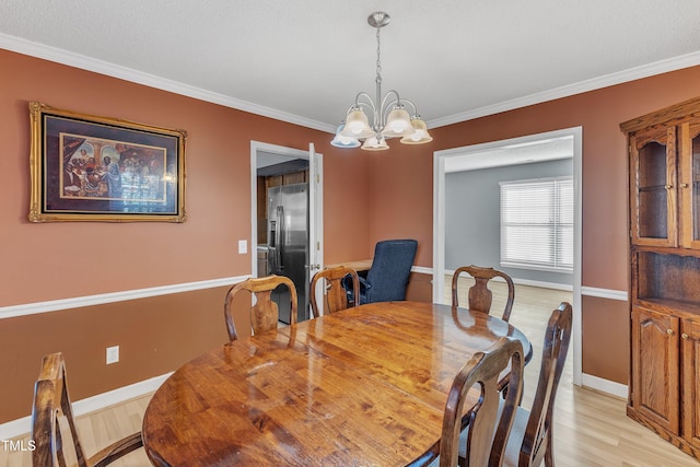 dining area with ornamental molding, a chandelier, and light hardwood / wood-style flooring