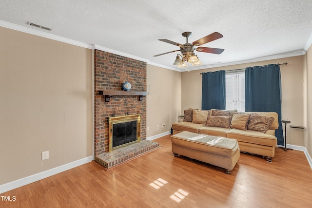 living room with a textured ceiling, ceiling fan, ornamental molding, and hardwood / wood-style flooring