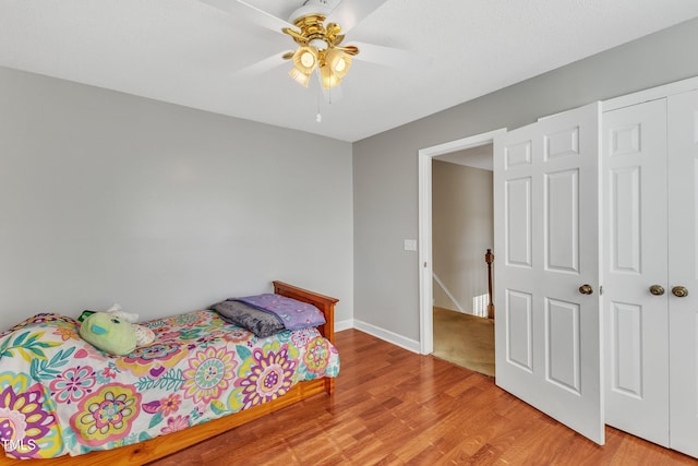 bedroom with ceiling fan, a closet, and light hardwood / wood-style flooring