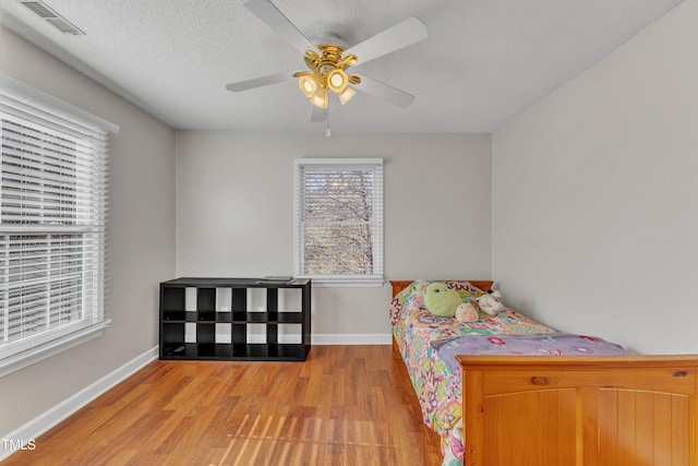 bedroom featuring a textured ceiling, ceiling fan, and light hardwood / wood-style floors