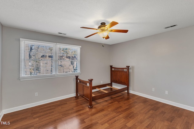 bedroom with ceiling fan, wood-type flooring, and multiple windows