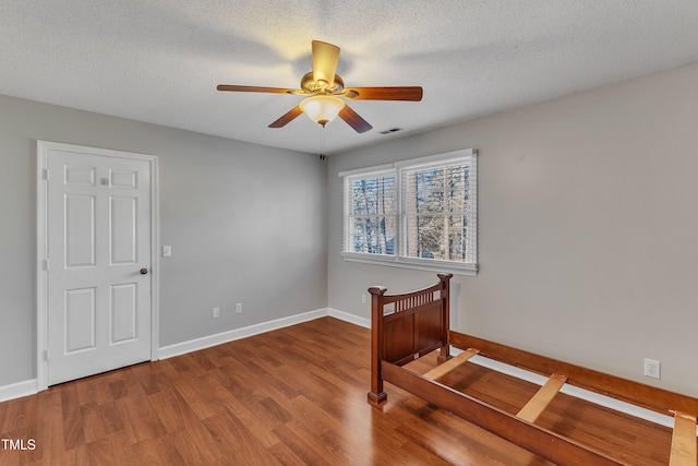 unfurnished room featuring ceiling fan, hardwood / wood-style floors, and a textured ceiling