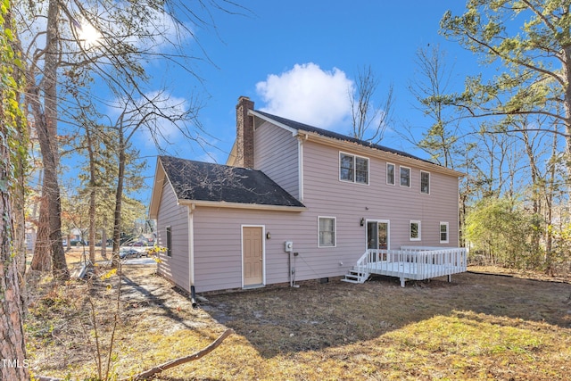 rear view of house with a deck and a lawn