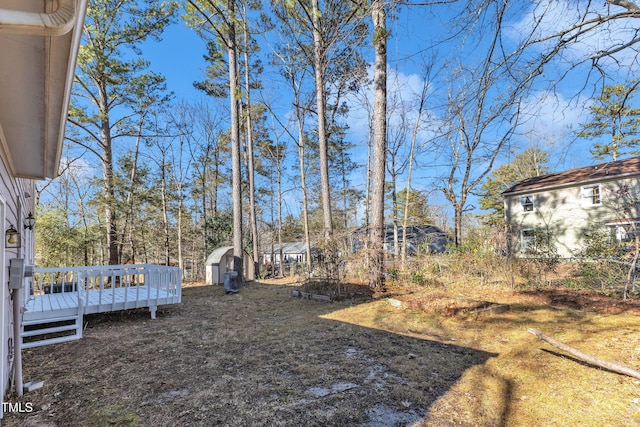 view of yard with a storage shed and a wooden deck