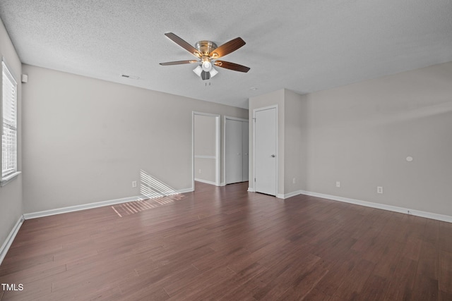 spare room with dark hardwood / wood-style flooring, ceiling fan, and a textured ceiling