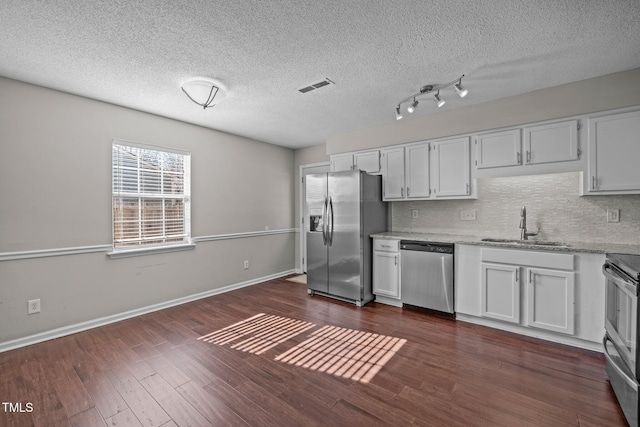 kitchen with white cabinetry, appliances with stainless steel finishes, dark hardwood / wood-style flooring, and sink