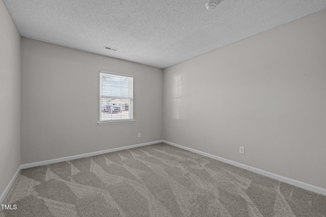 spare room with a textured ceiling and carpet flooring