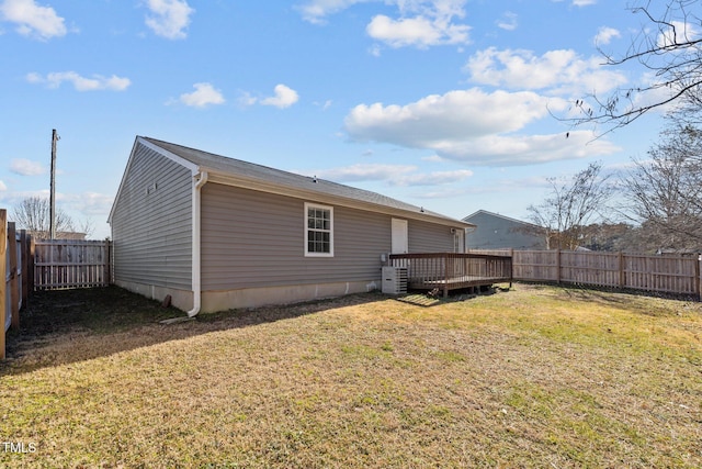 rear view of house featuring a wooden deck, central AC unit, and a lawn