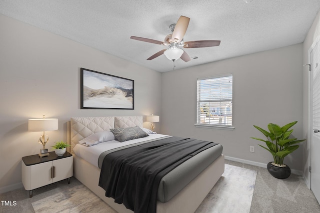 carpeted bedroom with a textured ceiling and ceiling fan