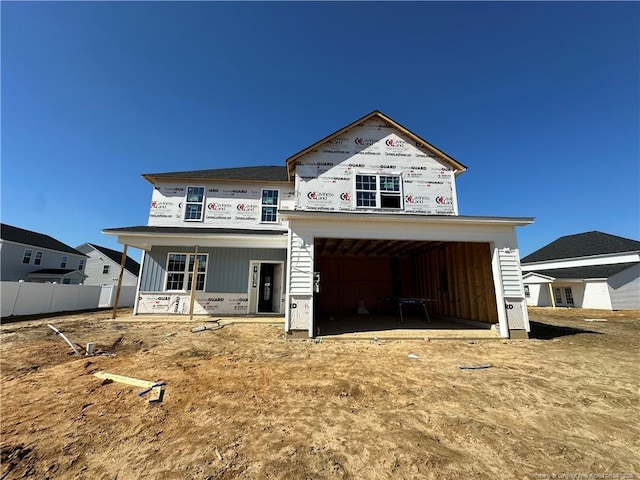 property in mid-construction featuring a garage, fence, and board and batten siding