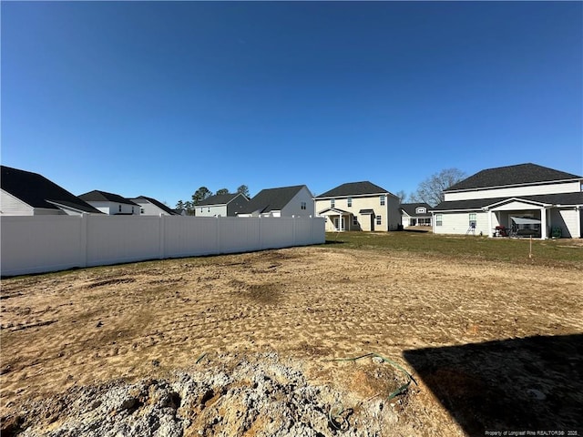 view of yard featuring fence and a residential view