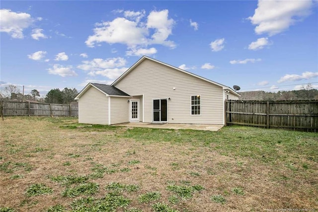 back of house with a patio area and a lawn