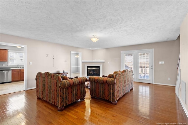 living room with sink, hardwood / wood-style floors, and a healthy amount of sunlight